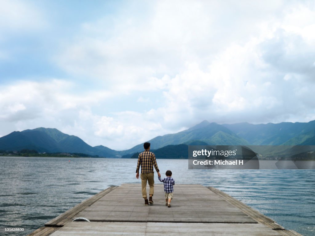 Father and son on a pier overlooking the lake