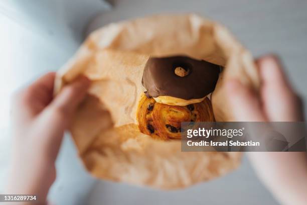 view from above of an unrecognizable girl holding a paper bag full of buns. you can see the buns inside. - person holding blank piece of paper stock pictures, royalty-free photos & images