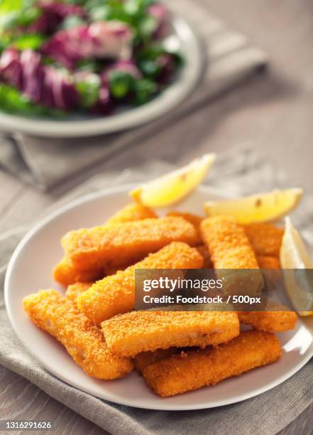 close-up of fried food in plate on table - fish fingers stockfoto's en -beelden