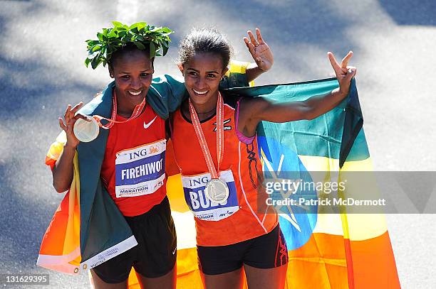 Firehiwot Dado of Ethiopia celebrates with Buzunesh Deba of Ethiopia after finishing in first and second place in the Women's Division of the 42nd...