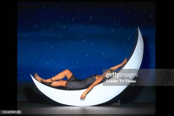 Television presenter Penny Smith laying on a crescent moon, circa 1999.
