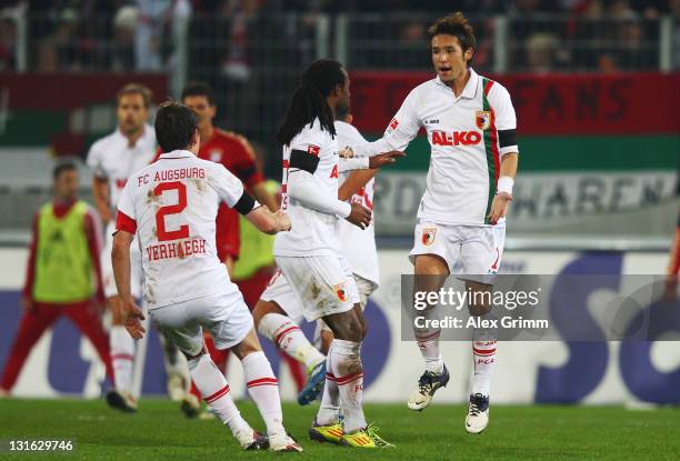 Hajime Hosogai of Augsburg celebrates his team's first goal with team mates during the Bundesliga match between FC Augsburg and FC Bayern Muenchen at...