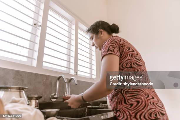 housewife washing cleaning dishes in kitchen - stereotypical homemaker stock pictures, royalty-free photos & images