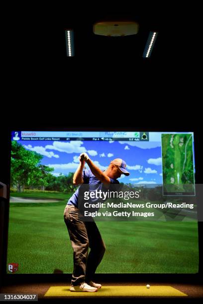 Joe Klusewitz of Exeter swings during a virtual game of golf, playing on the Pebble Beach golf course, inside of Swing Revolution on Wednesday,...