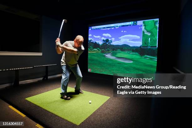 Mike Volon of Mohnton swings the golf club during a virtual game of golf, playing on the Pebble Beach golf course, inside of Swing Revolution on...