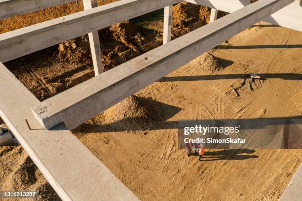 travailleurs de la construction debout sous la structure de la charpente - aerial view construction workers photos et images de collection