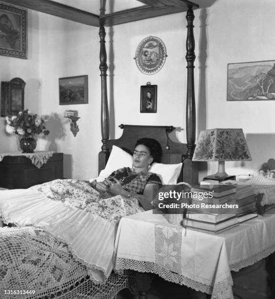 View of Mexican artist Frida Kahlo as she lies in bed at her home, La Casa Azul, Coyoacan, Mexico City, Mexico, 1952. A mirror affixed to the bed...
