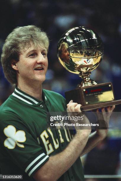 American basketball player Larry Bird, of the Boston Celtics, holds up his trophy, after winning the 1986 Three Point Contest at Reunion Arena,...