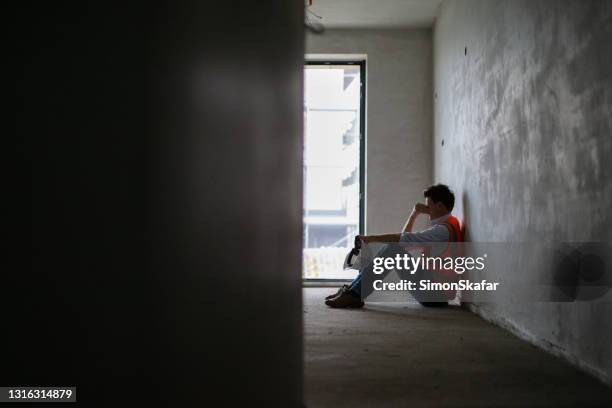 worried building contractor sitting inside at construction site - depression stock pictures, royalty-free photos & images