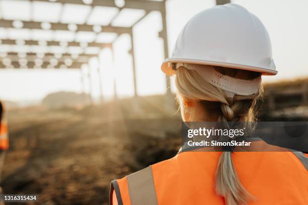 female engineer evaluating work at construction site - hard hat stock pictures, royalty-free photos & images