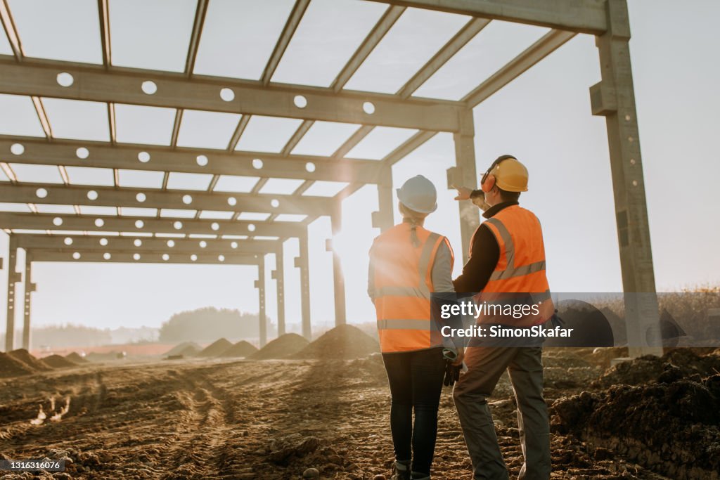 Contractor In Construction Building Contractors Discussing Work At Construction Site High-Res ...