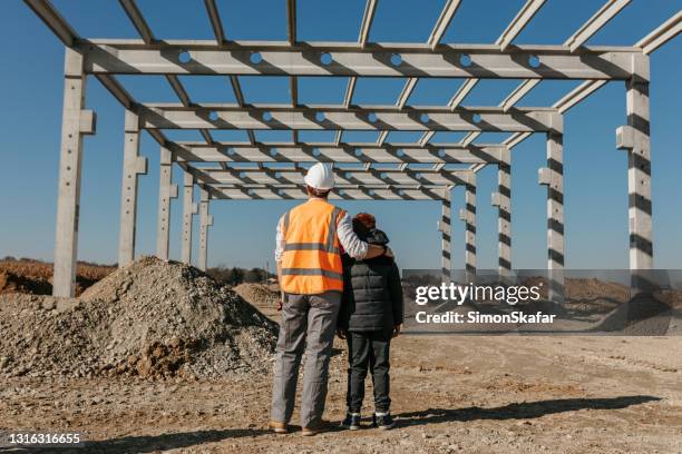 father and son at the construction site - youth foundation stock pictures, royalty-free photos & images