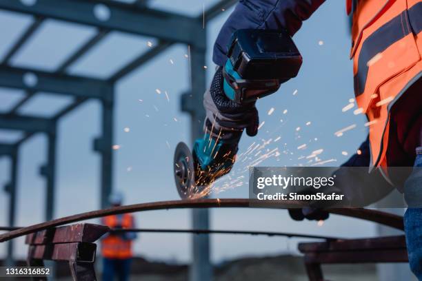 carpintero cortando hierro usando sierra circular - carpintería fotografías e imágenes de stock