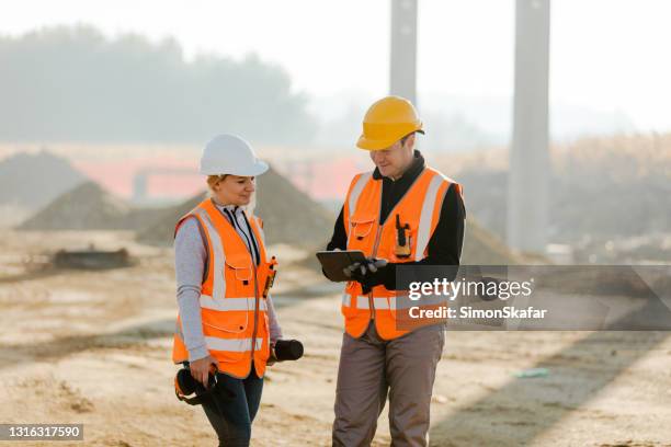 architechts mit digitalem tablet auf der baustelle - foundations gender equality discussion stock-fotos und bilder