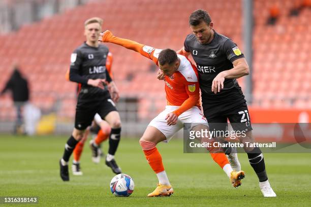 Jerry Yates of Blackpool is challenged by Andrew Butler of Doncaster Rovers during the Sky Bet League One match between Blackpool and Doncaster...