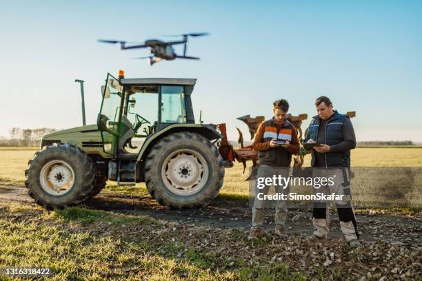 lavoro di squadra, utilizzo di tablet digitale e drone sul campo - drone agriculture foto e immagini stock
