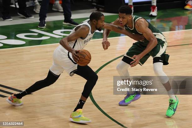 Kevin Durant of the Brooklyn Nets is defended by Giannis Antetokounmpo of the Milwaukee Bucks during a game at Fiserv Forum on May 02, 2021 in...