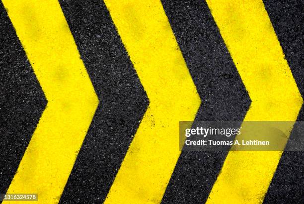 top view of dark wet asphalt road with three yellow arrow signs. - urban road sign stock pictures, royalty-free photos & images