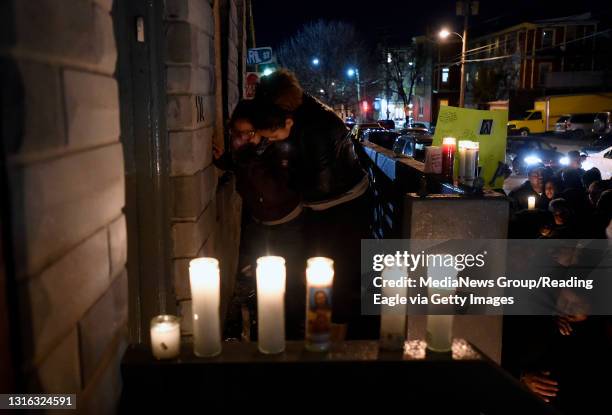 Two women cry on the front porch of the row home.Mourners gather outside 524 Spruce St. In Reading for a candlelight vigil in memory of Pedro Morales...