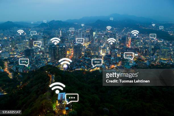 wi-fi and message icons on scenic view of city skyline and namsan hill in seoul, south korea, from above at dusk. - namsan stock pictures, royalty-free photos & images