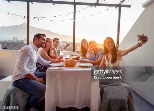 grupp av vänner som tar en selfie eller ett videosamtal på en middagsbjudning med en mobiltelefon - restaurant patio bildbanksfoton och bilder