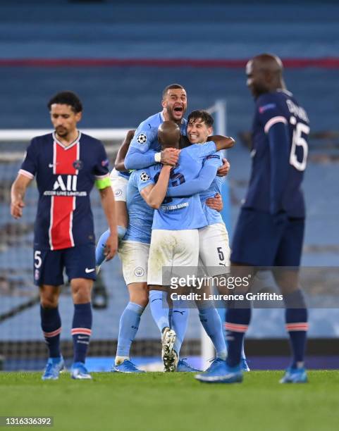 Kyle Walker of Manchester City celebrates victory with Fernandinho and John Stones of Manchester City as Marquinhos and Danilo Pereira of Paris...