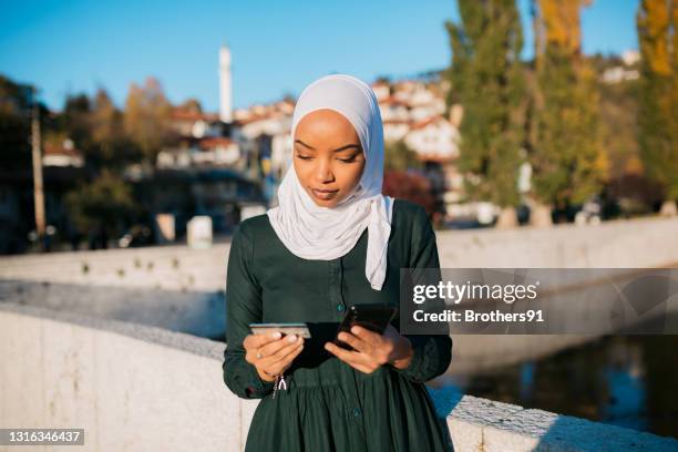 beautiful young woman of middle eastern ethnicity enjoying the day outdoors - islamic finance stock pictures, royalty-free photos & images