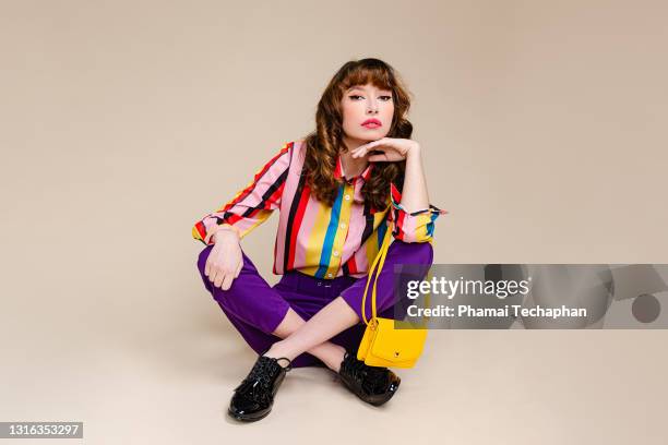 fashionable woman in retro style clothes - multi colored purse stock-fotos und bilder