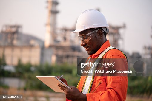 Engineer using tablet near oil refinery Engineer using tablet near oil refinery