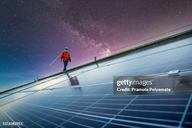 engineer working on checking equipment in solar power plant on the roof, solar energy technology concept  and the energy concept of the universe and galaxies - rooftop at night stock pictures, royalty-free photos & images