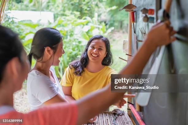 group of asian volunteers taking out garden equipment from the shed - chinese indonesians stock pictures, royalty-free photos & images