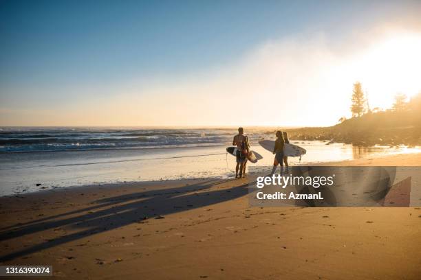 fernansicht der gold coast surfer, die am rande des wassers sprechen - mittlere entfernung stock-fotos und bilder