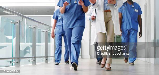 imagen recortada de un grupo diverso de médicos que caminaban por el pasillo del hospital - hospital staff fotografías e imágenes de stock