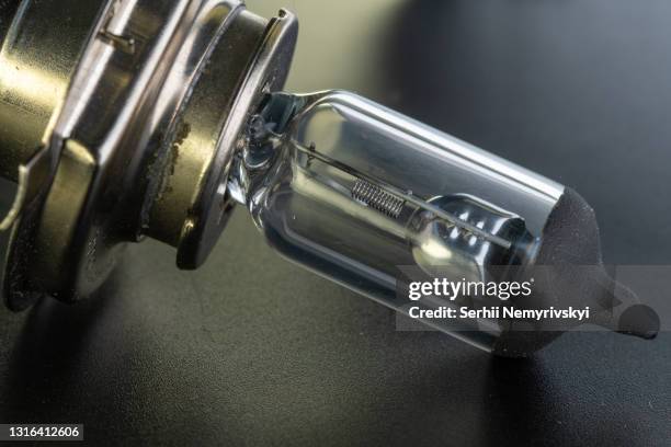 car main classic halogen bulb. filament, glass and metal, high energy consumption. black background. close-up view. copy space. h4 - car lights stock pictures, royalty-free photos & images