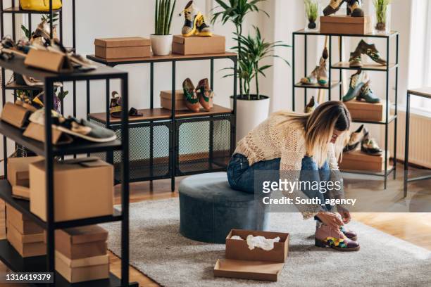 woman trying on shoes - shoe boxes stock pictures, royalty-free photos & images