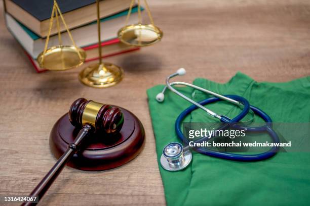 a gavel and a stethoscope on a wooden table concept of medical and legal industries. - prosecution stock pictures, royalty-free photos & images