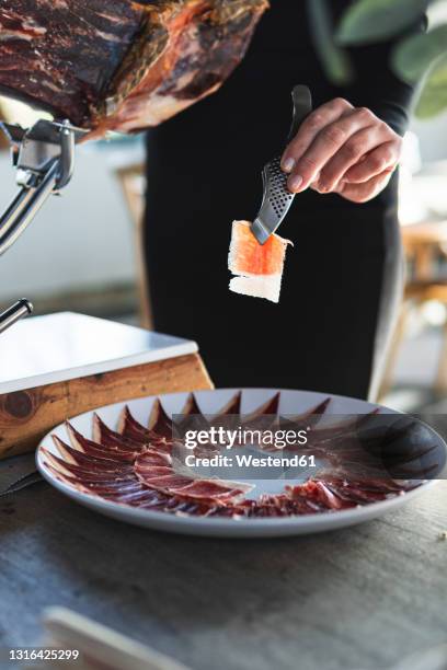 female chef arranging slices of ham on table at restaurant - plate side view stock pictures, royalty-free photos & images