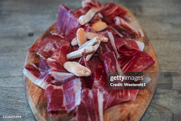 slices of ham on wooden plate in restaurant - iberia stock pictures, royalty-free photos & images