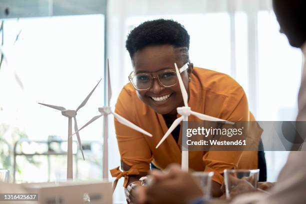 smiling woman leaning on desk at coworking office - mens hair model stock pictures, royalty-free photos & images