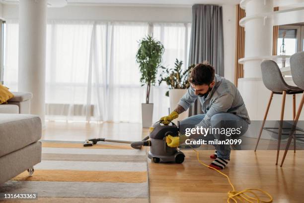 mann zu hause staubsaugerreinigung - vacuum cleaner stock-fotos und bilder