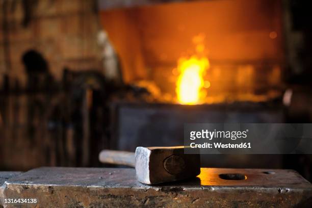 hammer on anvil at blacksmith's shop - amboss stock-fotos und bilder