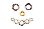 Set of brass multicoloured metal eyelets or rivets - curtains rings for fastening fabric to the cornice, isolated on white background with copyspace for text. Catalogue photo, selective focus