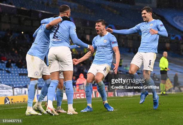 Riyad Mahrez of Manchester City is congratulated on scoring his team's second goal by Ruben Dias and John Stones during the UEFA Champions League...