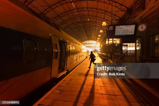 man running to catch a train on den haag hollands spoor train station - train photos et images de collection