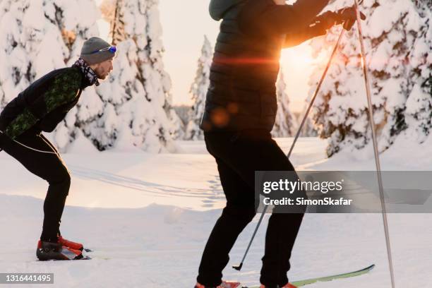 men skiing in snow during sunset - cross country skiing stock pictures, royalty-free photos & images