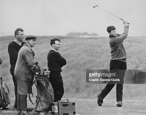 Eighteen years old British golfer Peter Oosterhuis watches his drive off the third tee watched by Great Britain and Ireland team mates Michael...