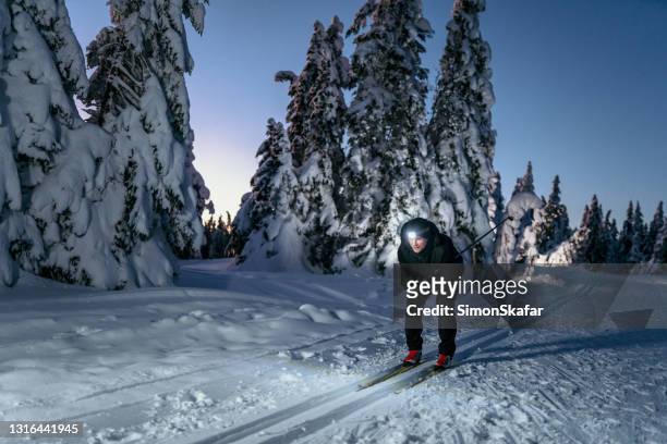 men skiing at night - night skiing stock pictures, royalty-free photos & images