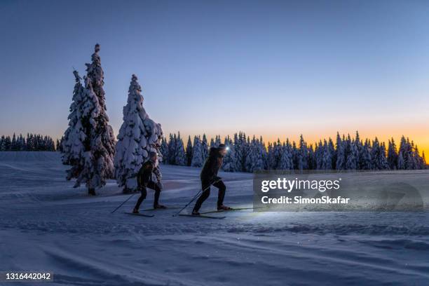 mensen die op skihelling bij nacht skiën - skischoen stockfoto's en -beelden