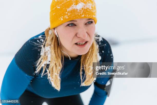 müde frau nach joggen im schnee - müdigkeit winter stock-fotos und bilder