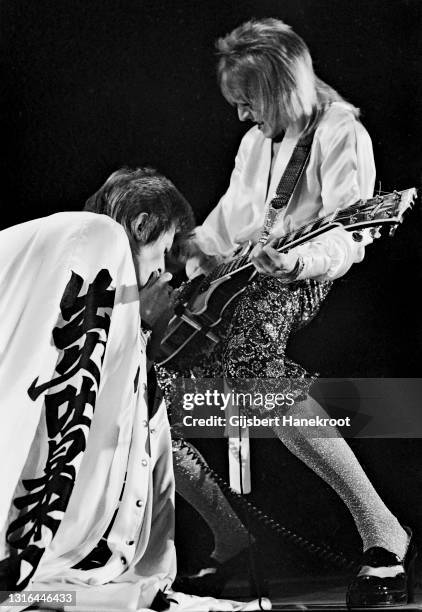 David Bowie, dressed as his Ziggy Stardust character, performs on stage with Mick Ronson of the Spiders From Mars at Earl's Court Arena, London, on...